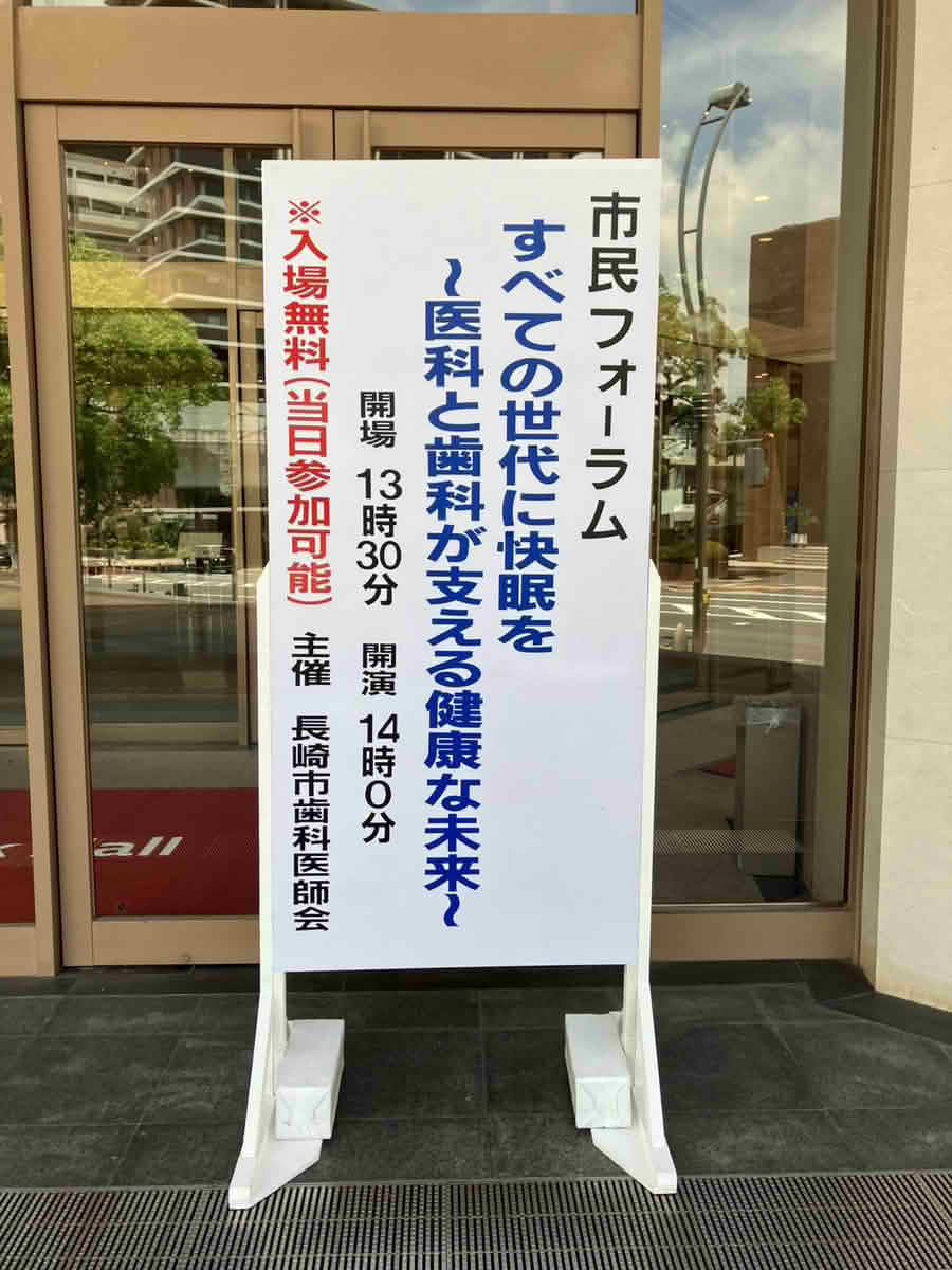 ベネックス長崎ブリックホール入口に設置された、市民フォーラム「すべての世代に快眠を～医科と歯科が支える健康な未来～」の会場案内看板